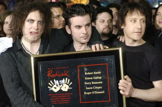 FILE – Robert Smith, left, Simon Gallup, center, and Perry Bamonte of British rock group The Cure hold a plaque after being inducted into Hollywood’s Rockwalk in Los Angeles, Friday, April 30, 2004. (AP Photo/Chris Pizzello, File)
