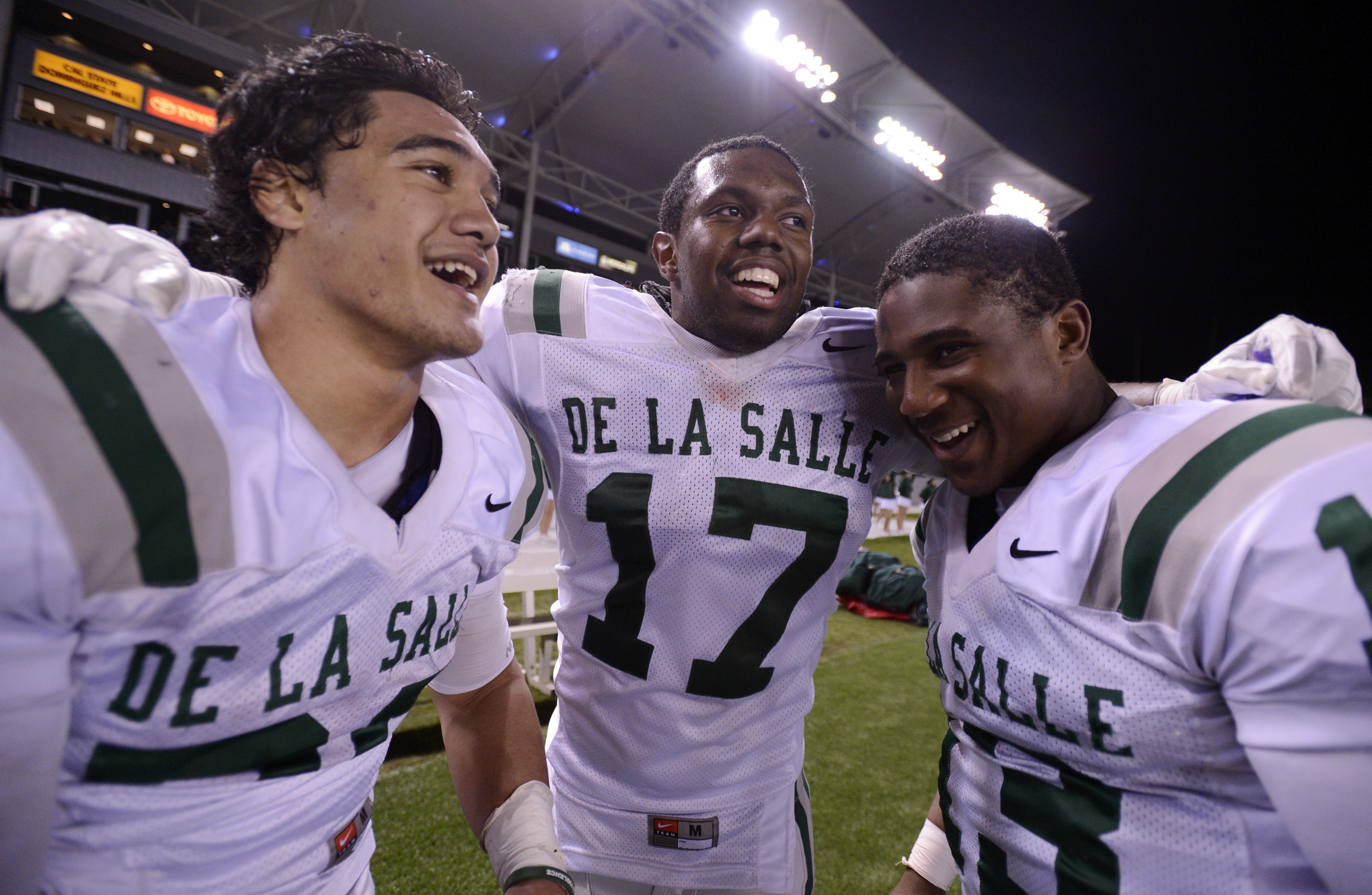 De La Salle Spartans' Tiapepe Vitale (20), Michael Hutchings (17) and Chris Williams (13) celebrate their win in the final minute of the fourth quarter against the Centennial Huskies in the Open Division during the 2012 CIF State Football Championship at Home Depot Center in Carson , Calif. on Saturday, Dec. 15, 2012. De La Salle defeated Centennial 48-28. (Jose Carlos Fajardo/Staff)