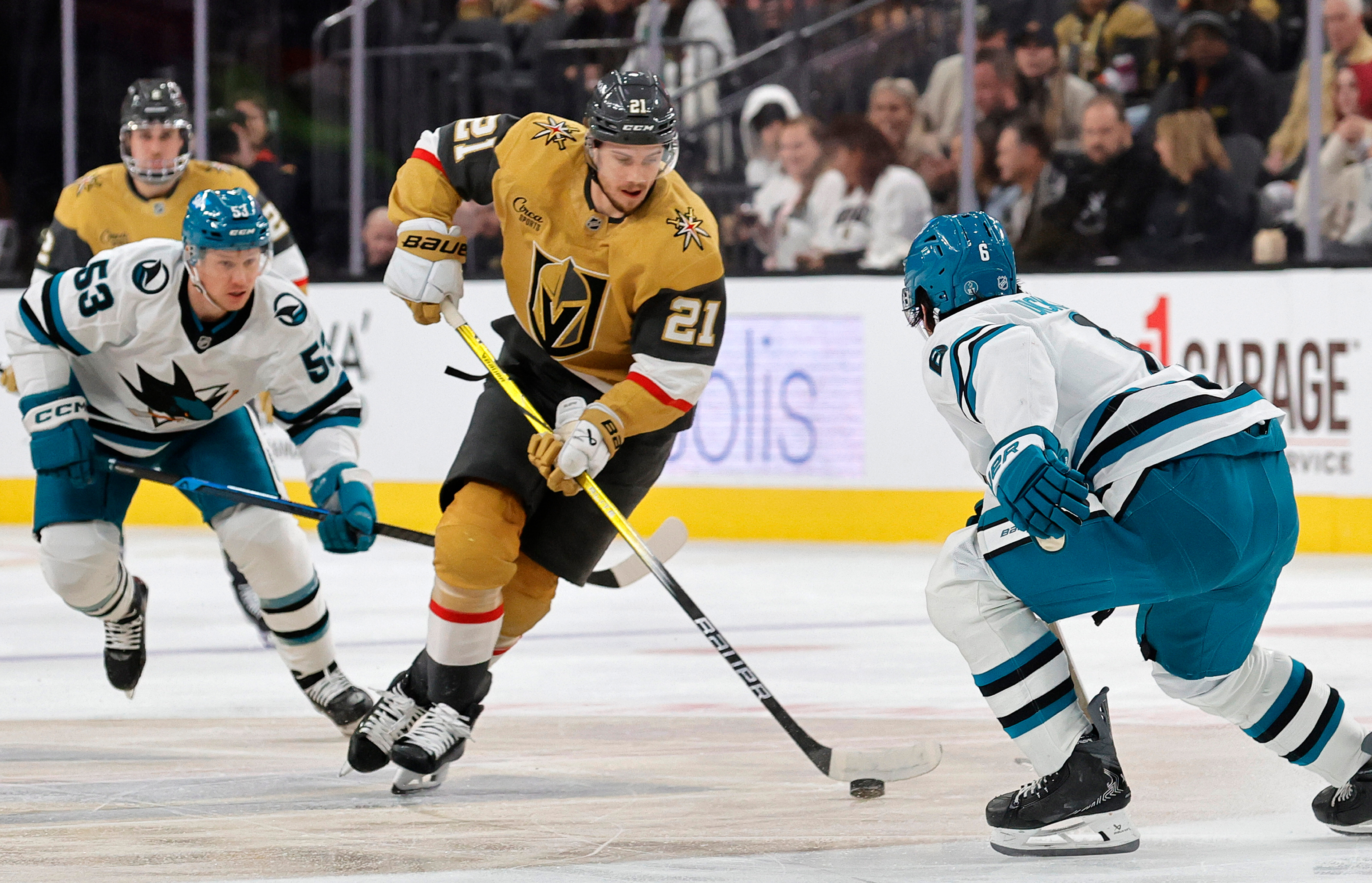 Vegas Golden Knights center Brett Howden (21) skates between San Jose Sharks left wing Jeff Skinner (53) and defenseman Sam Dickinson (6) during the second period of an NHL hockey game Tuesday, Dec. 23, 2025, in Las Vegas. (AP Photo/Steve Marcus)